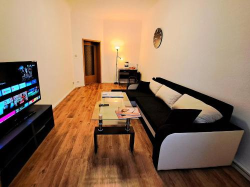 ein Wohnzimmer mit einem Sofa und einem Couchtisch in der Unterkunft Apartment Hotel Adler Leipzig in Leipzig