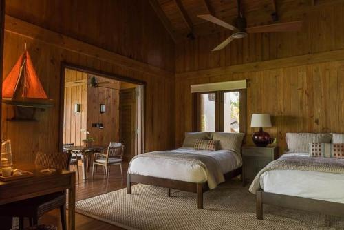a bedroom with two beds in a room with wooden walls at Sunny Vacation Villa No 41 in San Rafael del Yuma