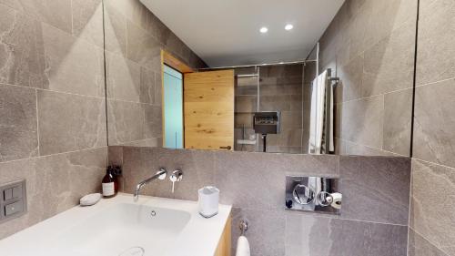 a bathroom with a sink and a mirror at Cresta Ellie in St. Moritz