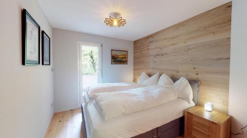 a bedroom with a large bed with a wooden wall at Cresta Ellie in St. Moritz