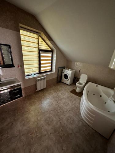 a bathroom with a tub and a sink and a toilet at Xanagah Villa in İsmayıllı