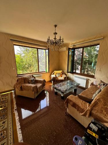 a living room with two couches and a chandelier at Xanagah Villa in İsmayıllı