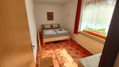 um pequeno quarto com uma cama e uma janela em Prague Zbraslav Old Garden em Praga