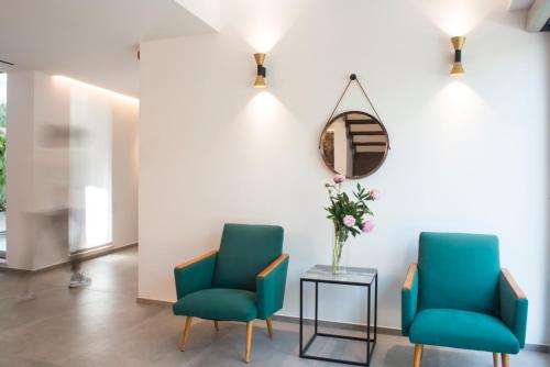 two chairs and a table in a room with a mirror at Spazio Gagarin Residence in Matera