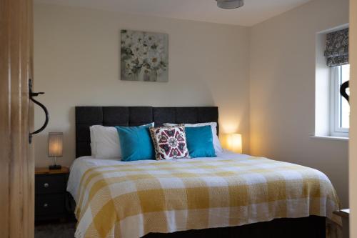 a bedroom with a large bed with blue pillows at Brecon Beacons Cottage with Stunning Country Views in Myddfai