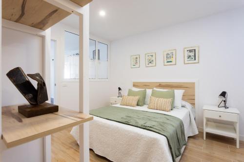 ein weißes Schlafzimmer mit einem Bett und einem Tisch in der Unterkunft Finca Villa Huerta in Icod de los Vinos