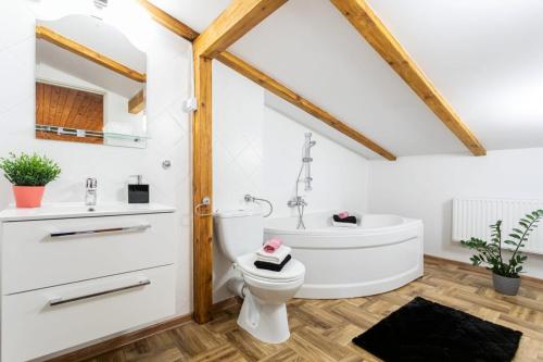 a bathroom with a white tub and a toilet and a sink at Dolce Vita in Gdańsk