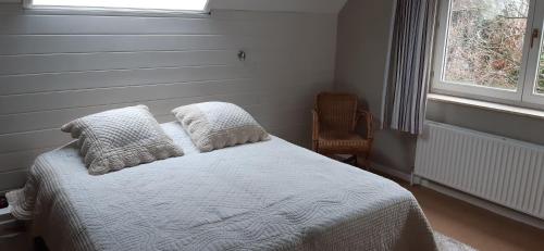 een slaapkamer met een bed met kussens en een raam bij Les 3 Fontaines in Verviers