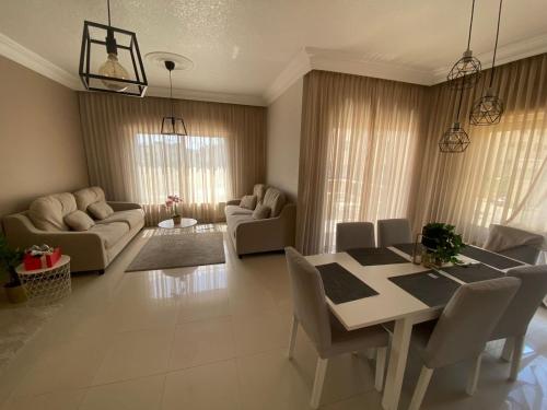 ein Wohnzimmer mit einem Esstisch und Stühlen in der Unterkunft Modern chic haven in Amman