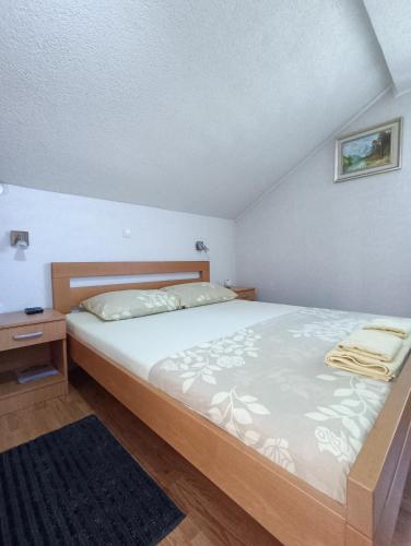 a bedroom with a large bed and a nightstand at Guesthouse Nikolina in Korenica