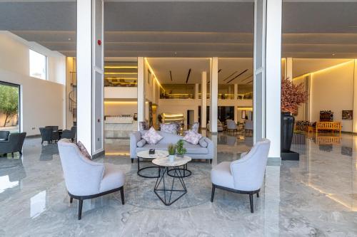 um átrio com um sofá, cadeiras e uma mesa em فندق هوليداي الخليج النجاح em Riade
