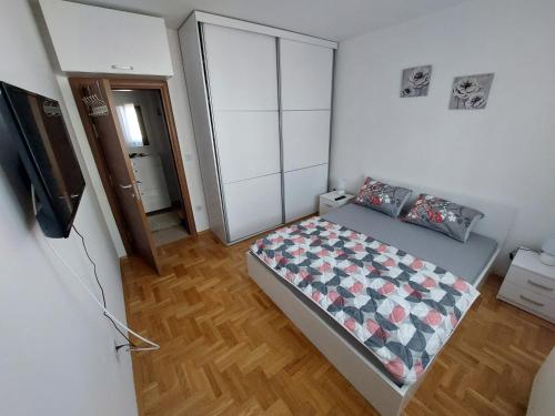 a small bedroom with a bed and a television at Apartment Gelić Family in Kumanovo