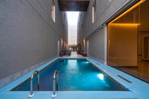 a swimming pool in a building with two faucets at XYZ Hotel Al Najah in Riyadh