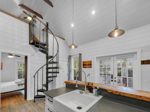 a bathroom with a sink and a spiral staircase at Cozy Island Cottage in Charleston