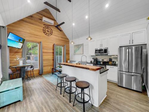 a kitchen with white cabinets and a bar with stools at Cozy Island Cottage in Charleston