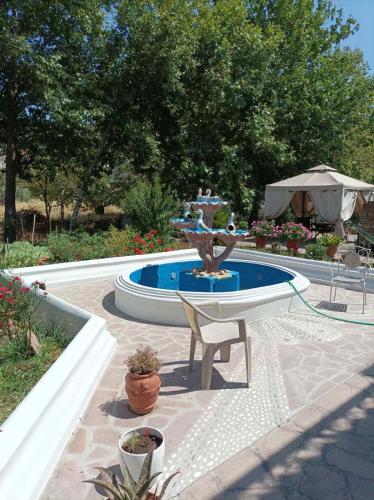 a fountain in the middle of a patio with a chair at Mountain Voyage Residences in Vatoússa