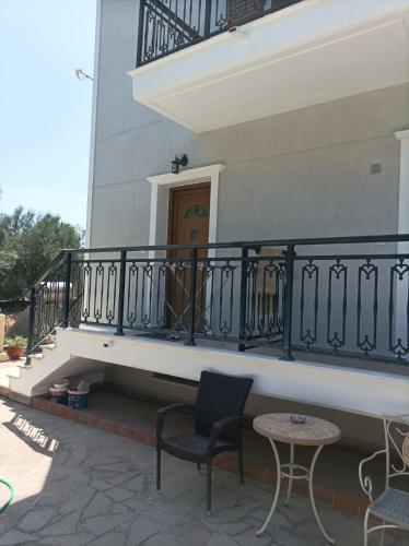a balcony of a building with two chairs and a table at Mountain Voyage Residences in Vatoússa