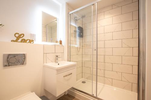 baño blanco con ducha y lavamanos en 出入平安 BUSINESS OR PLEASURE! NEW Southampton 'City Vibes' # Super Central & Stylish Apartment with Outside Space! for 1-4 Guests BOOK YOUR CITY BREAK or PRE-CRUISE STAY! CLOSE TO MAYFLOWER THEATRE, UNIVERSITIES, CRUISE TERMINALS, HOSPITALS & SHOPS!, en Southampton