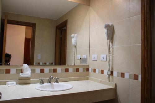 baño con lavabo y teléfono en la pared en Hotel Bella Costa en La Lucila del Mar