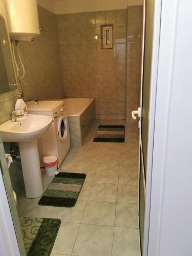 a bathroom with a sink and a toilet and a shower at La Bloc in Băile Herculane