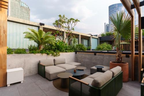a rooftop patio with couches and tables on a building at Volga in Mexico City
