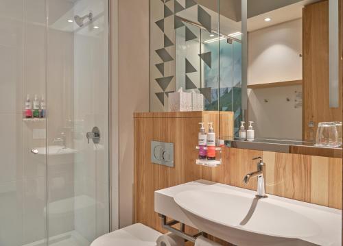 a bathroom with a sink and a shower at Alt Hotel Calgary University District in Calgary