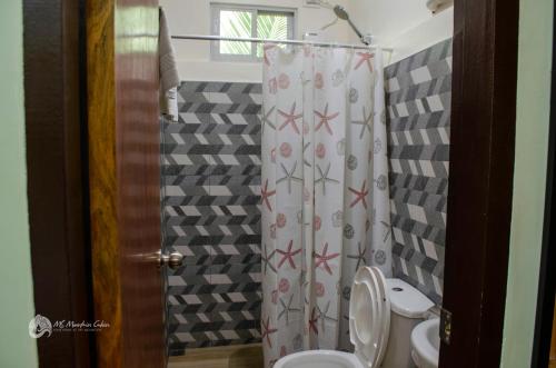 a bathroom with a shower curtain with a toilet at MS Mountain Cabin in Loboc