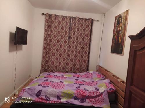 ein kleines Schlafzimmer mit einem Bett mit einer lila Tagesdecke in der Unterkunft Appartement Magnifique dans un beau cadre in Brüssel