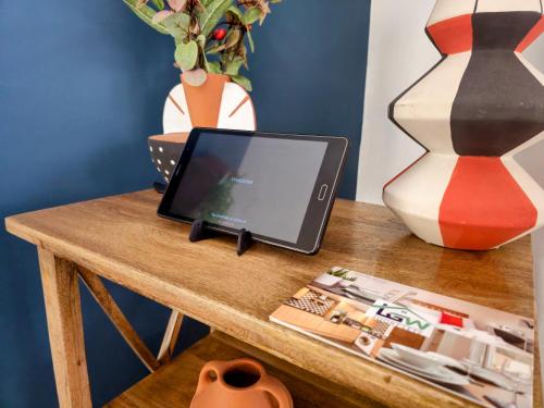 a laptop computer sitting on top of a wooden table at Gatwick Place - 4 bed 2 bath self contained house with private garden in Horley