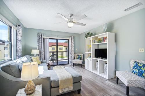 een woonkamer met een bank en een tv bij Cocoa Beach Vacation Rental - Walk to Pier! in Cocoa Beach