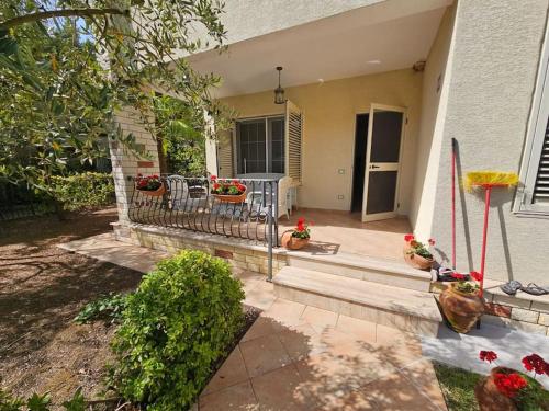 a porch of a house with potted plants on it at Golem Beach Villa in Golem