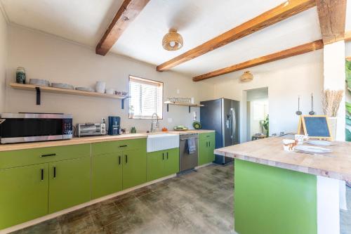 a kitchen with green cabinets and a counter top at NEW PROPERTY! The Cactus Villas at Joshua Tree National Park - Pool, Hot Tub, Outdoor Shower, Fire Pit in Twentynine Palms