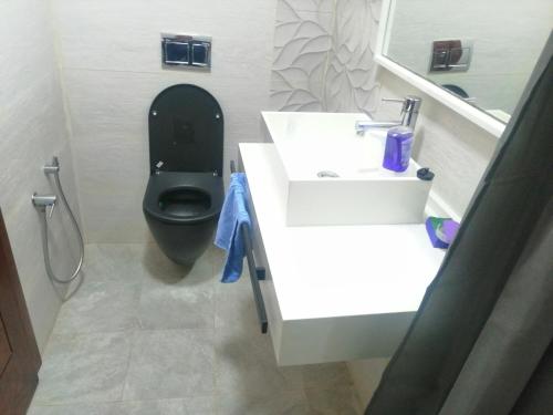 ein Bad mit einem schwarzen WC und einem Waschbecken in der Unterkunft Chez Zina in Tacape
