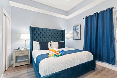a bedroom with a large bed with a blue headboard at Spectacular view Blue Heron Beach Resort Near Disney in Orlando