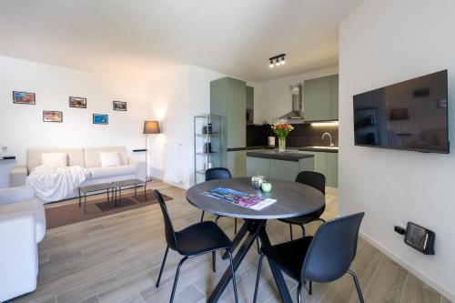een woonkamer en een keuken met een tafel en stoelen bij Lisa Como lake in Gravedona