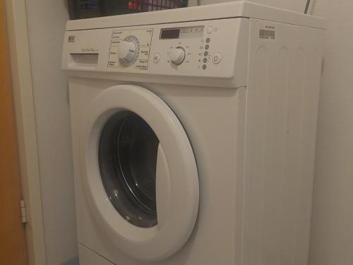 eine weiße Waschmaschine in einem Zimmer in der Unterkunft Lakeside Villa Lehtiniemi in Pirkkala