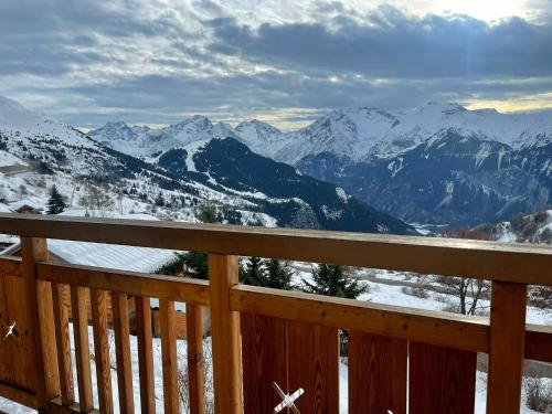 a view of the mountains from the deck of a cabin at Charmant Studio 4P Alpe d'huez in LʼHuez