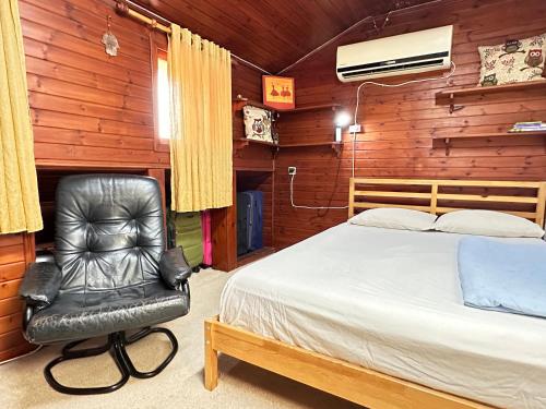 荷茲利亞的住宿－Cosy room near IDC & Center- Herzliya Homestay，一间卧室配有一张床和一张黑色皮椅