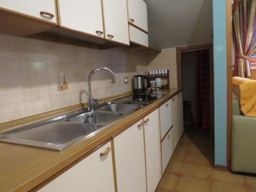 a kitchen with white cabinets and a sink at Giglio Della Montagna in Livigno