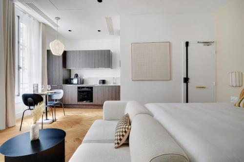 - une chambre blanche avec un canapé et une table dans l'établissement Wonderful studio - 2P - Opéra Garnier, à Paris