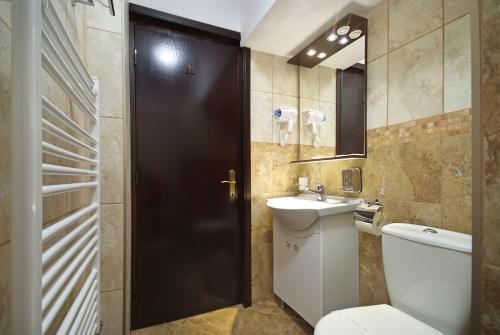 a bathroom with a toilet and a sink at Hotel Moldavia in Slănic-Moldova