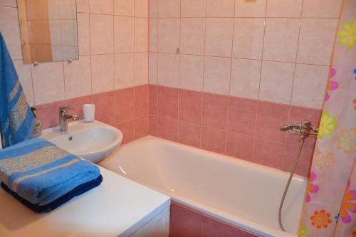 a bathroom with a bath tub and a sink at Julia Apartment Riga Imanta in Rīga