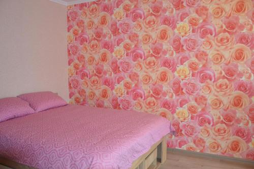 una camera con un letto e un muro di rose di Julia Apartment Riga Imanta a Riga