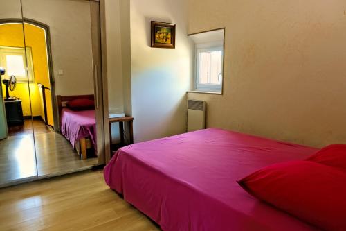 - une chambre avec un lit rose et un miroir dans l'établissement Mas Dante, à Cassis