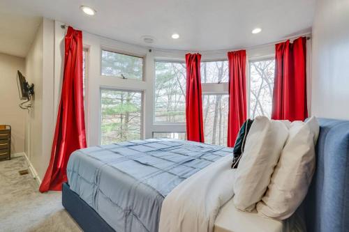a bedroom with a blue bed and red curtains at Unique Roundhouse: Hot Tub-Game Room-FirePit&More! in Bushkill