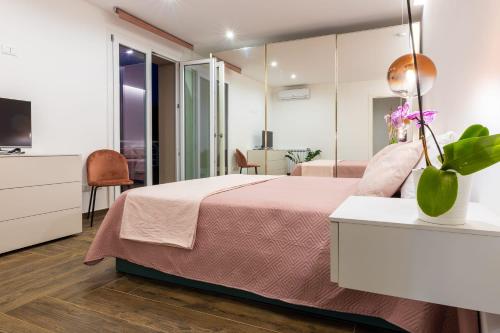 1 dormitorio con cama rosa y espejo en Rosina Apartment surfing bed&vacation, en Terrasini