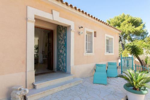 a patio with blue chairs and a house at Villa spa hamman sauna Piscine 9 chambres in Juan-les-Pins