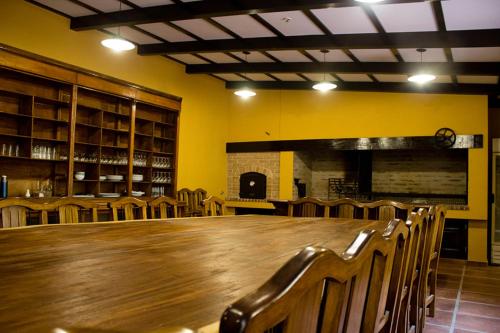 a dining room with a large wooden table and chairs at Hotel San Carlos in San Antonio de Areco