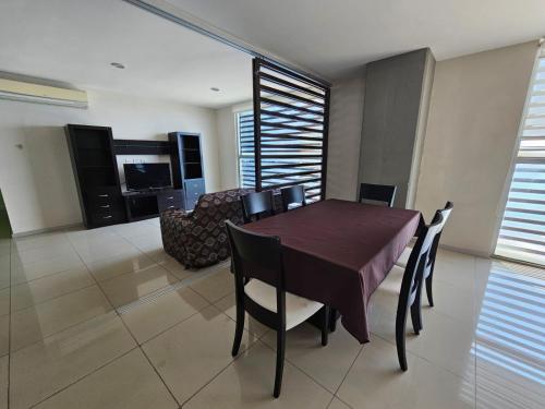 a dining room with a table and chairs and a couch at Hotel Torres Eugenia in Coatzacoalcos