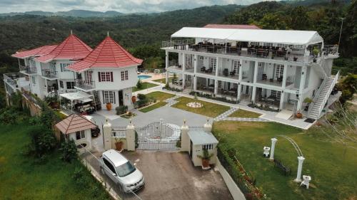 a large white house with a car parked in front of it at Lavender Moon Villas in Breadnut Hill